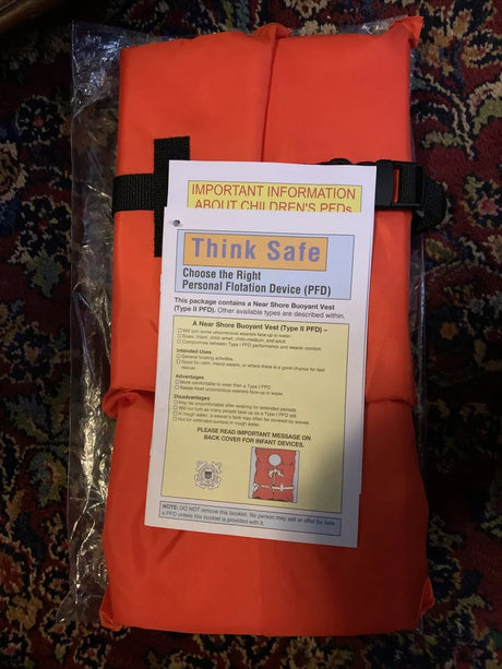 10000-02-A-OR Airhead Type II Keyhole Life Vest in orange packaging with safety information leaflet.